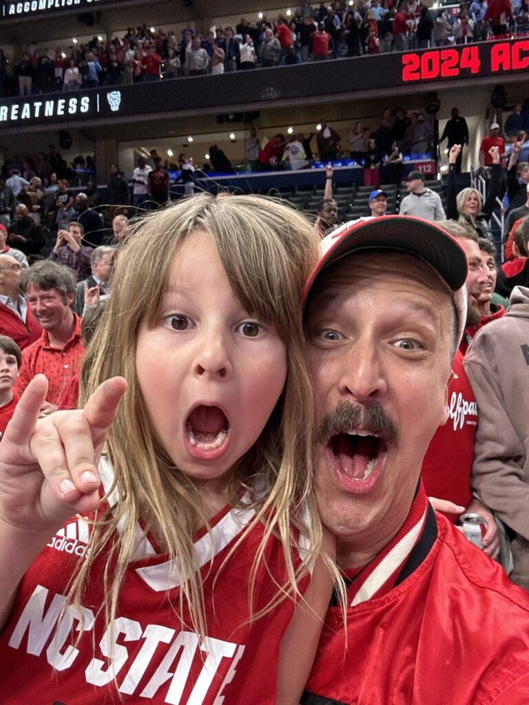 American Aquarium frontman BJ Barham celebrates NC State basketball's first ACC Tournament championship in 37 years with his daughter, Pearl.