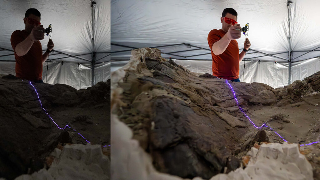 Paleontologist Eric Lund runs a high-powered light across a fossil to look for things like feathers and skin.