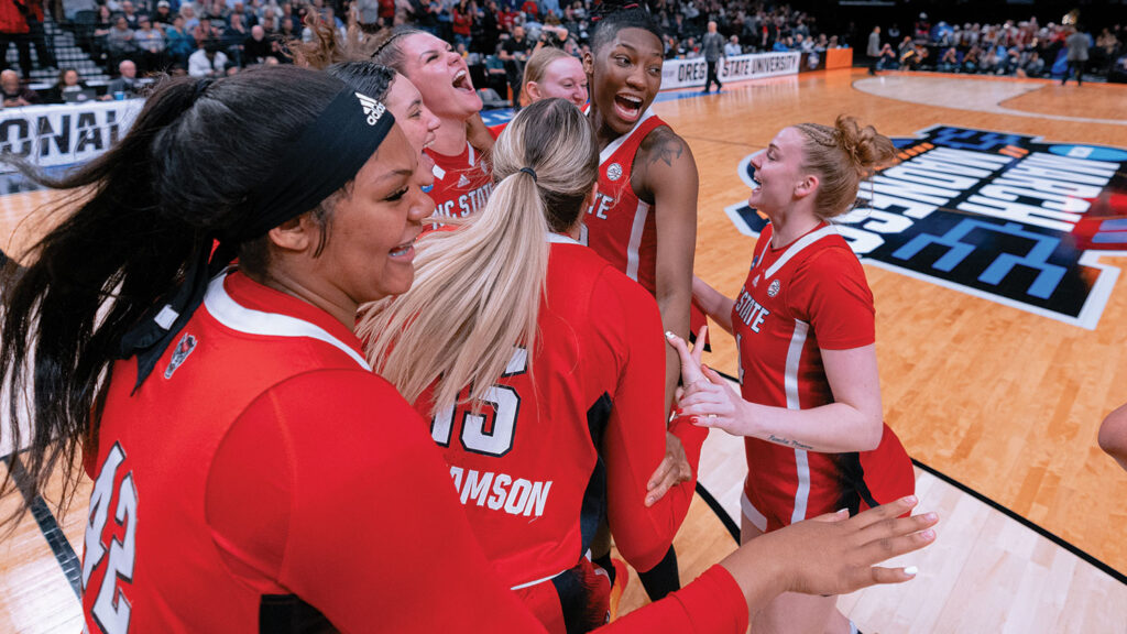 NC State women's basketball players celebrate a win. 