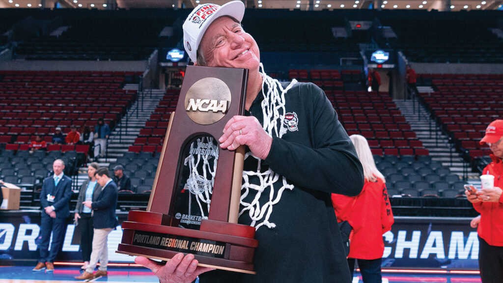 Wes Moore celebrates his team going to the Final Four by holding a regional trophy.