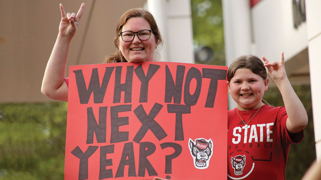 Fans hold a sign asking, "Why Not Next Year?"