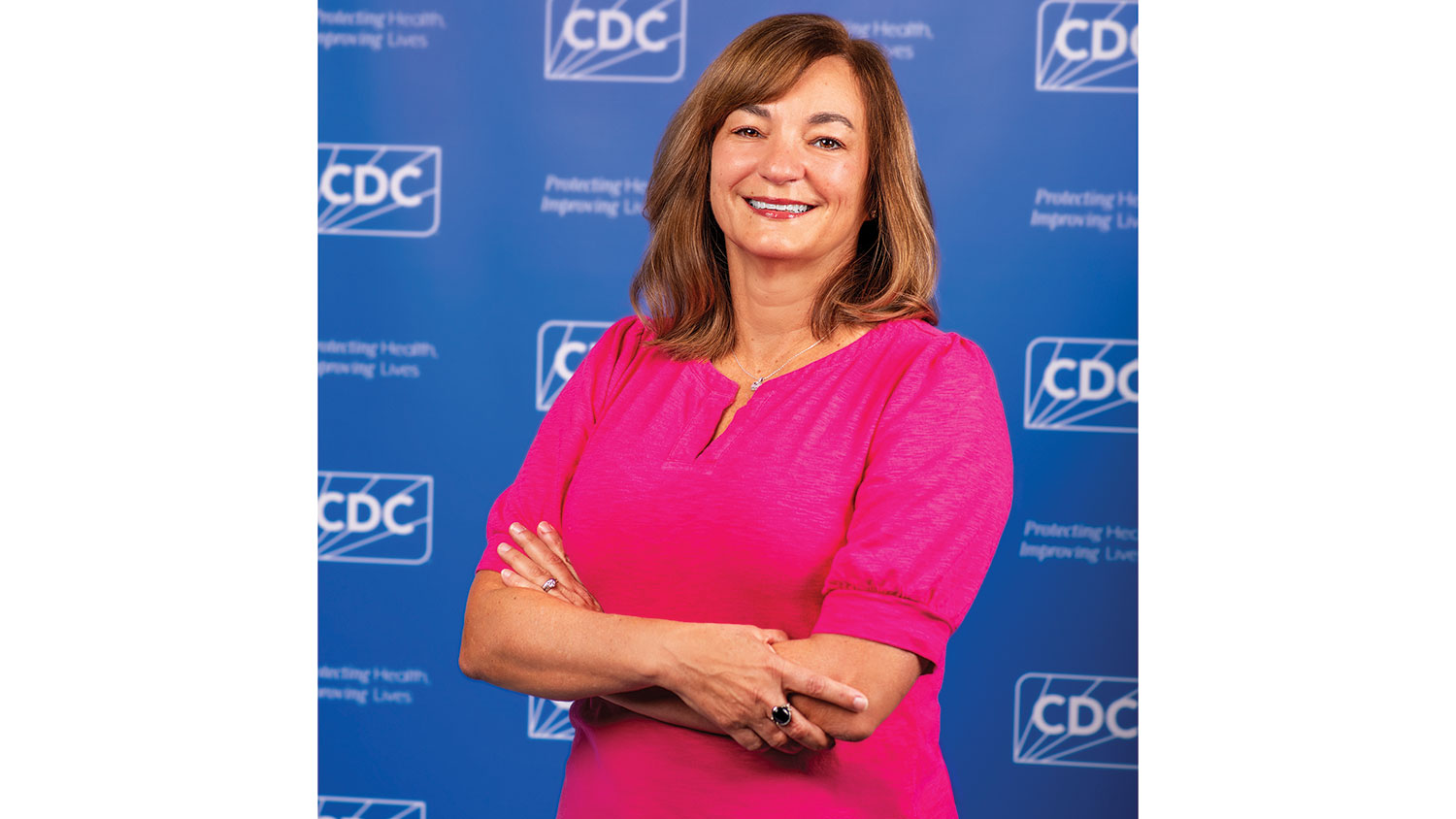 Laura Green Brown poses in front of an event-style background with the CDC logo on it.