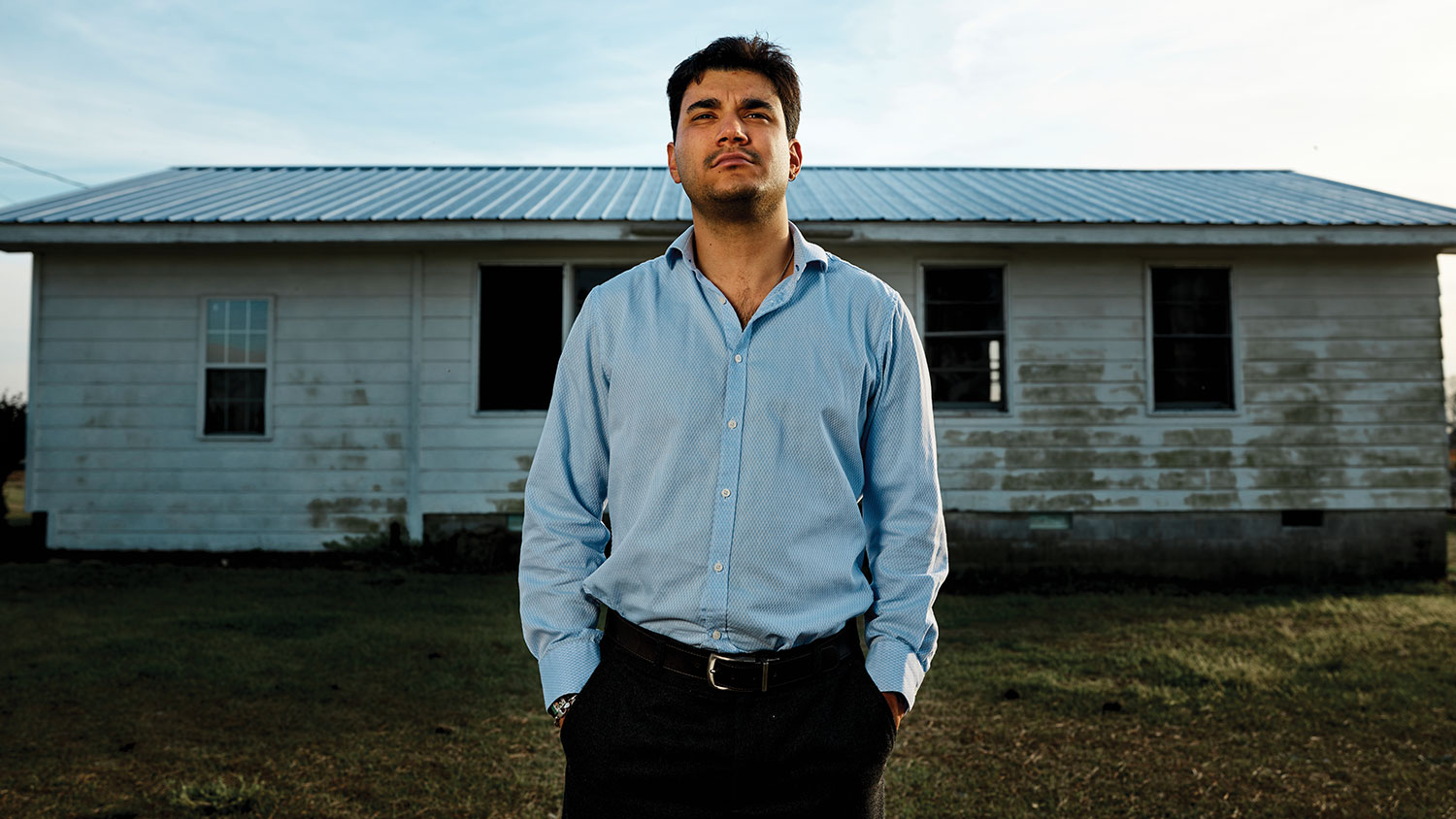 Aaron Sánchez-Guerra stands in front of a house.