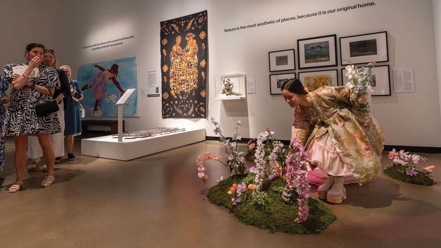 A model in a kimono picks flowers in the Gregg Museum as part of the "living" exhibit fashion show.