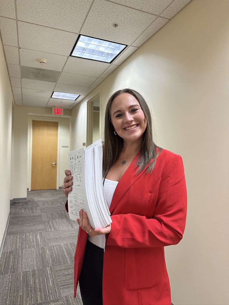 Natalie Gore stands in the hallway outside of offices for the Carolina Hurricanes.